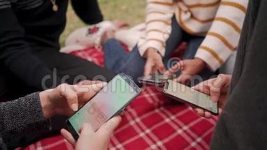 在公园里使用手机应用程序，为坐在<strong>红毯</strong>上的朋友提供特写